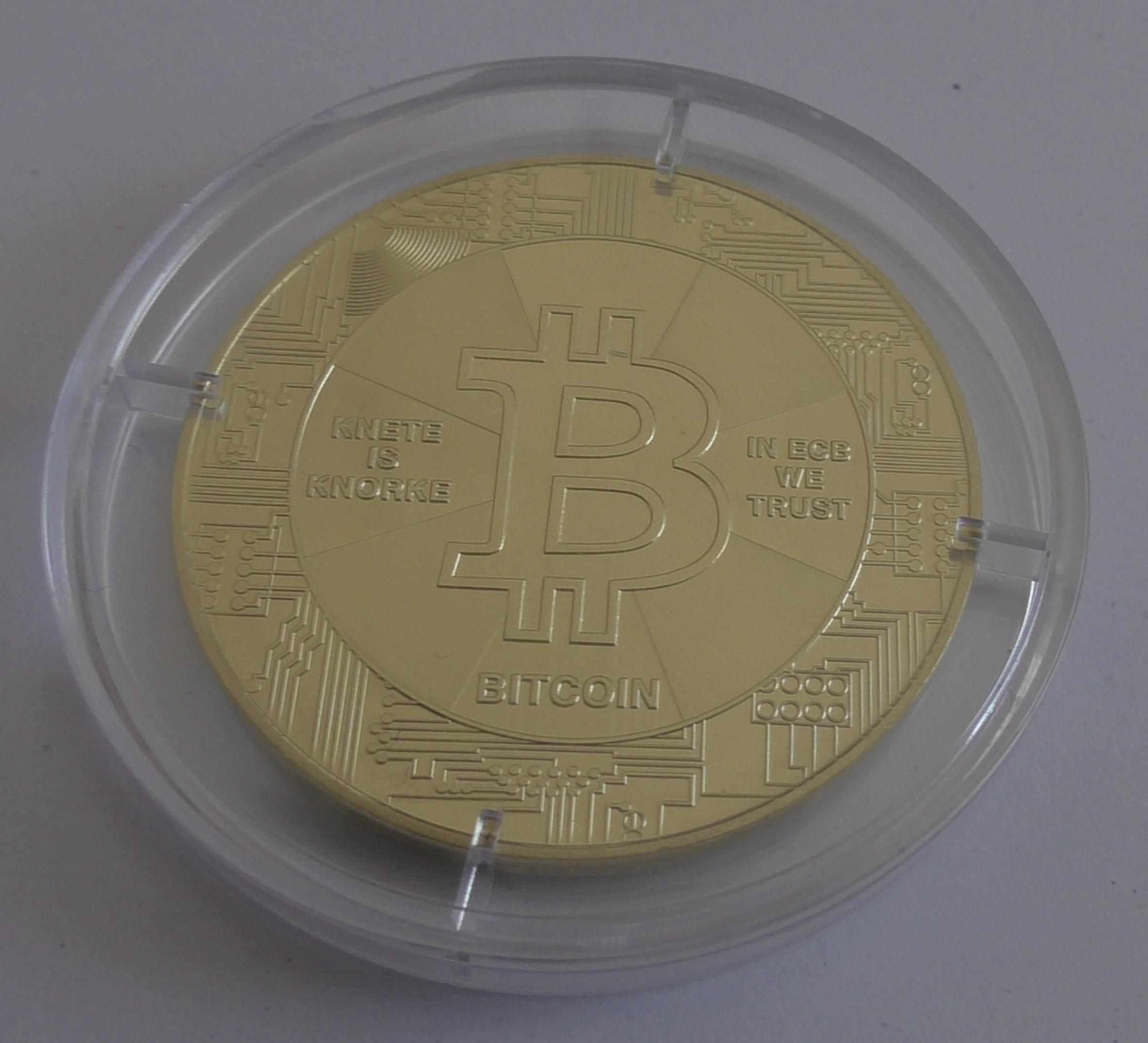 pièce physique de Bitcoin, gros plan, sous emballage plastique de protection