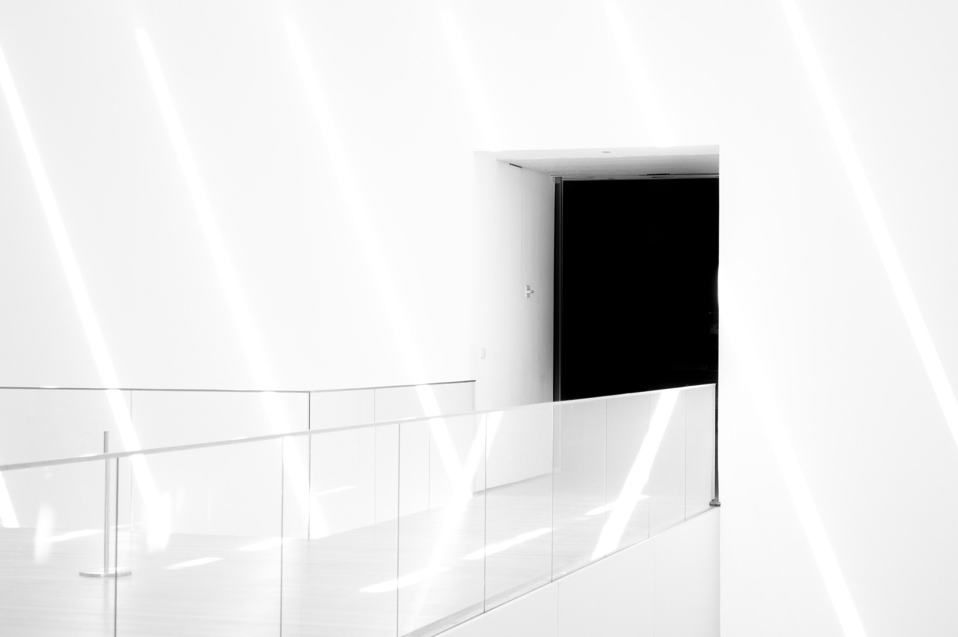 couloir intérieur clair et épuré avec une ouverture de porte sombre, architecture moderne
