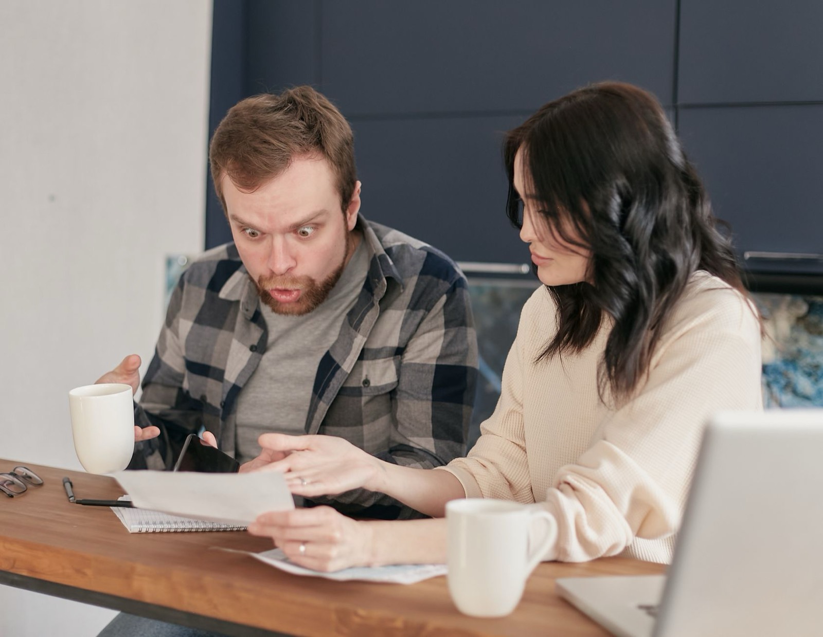 Un couple consulte des documents administratifs à table