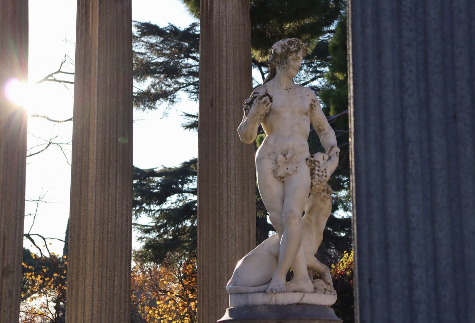 Statue en pierre installée dans un jardin, entourée de végétation